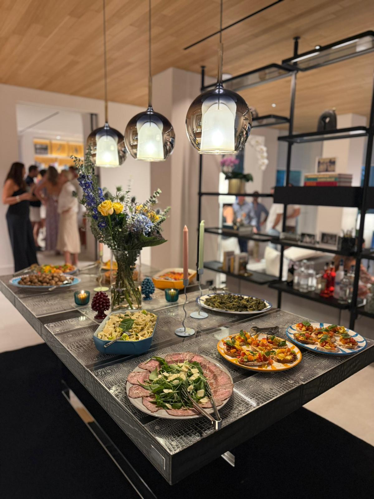 Antipasti laid out on a table in a private home, guests behind