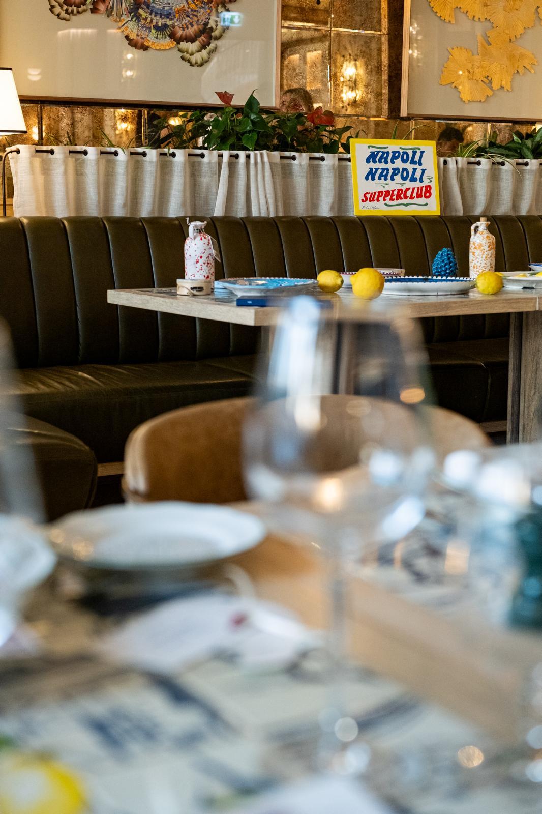 The room at Jou Jou Brasserie laid for the evening, the hand-painted Napoli Napoli Supperclub sign above the banquette